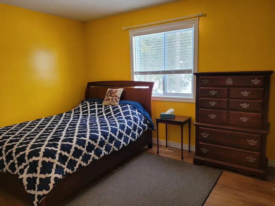 Bright bedroom with queen bed and yellow walls
